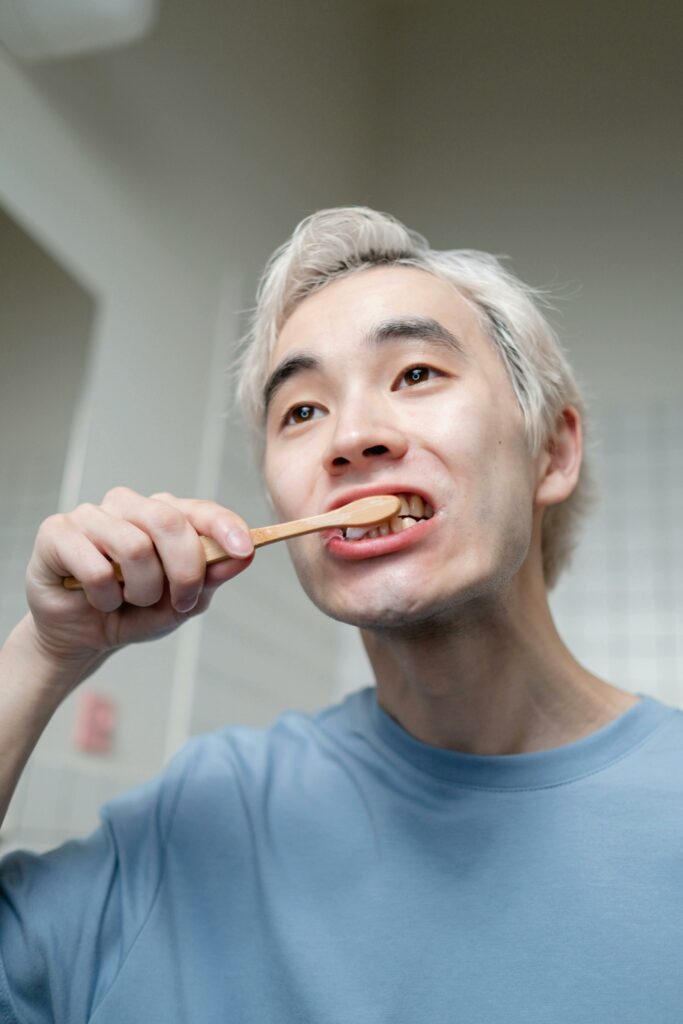 A man brushing his teeth  To maintain his Healthy habits.