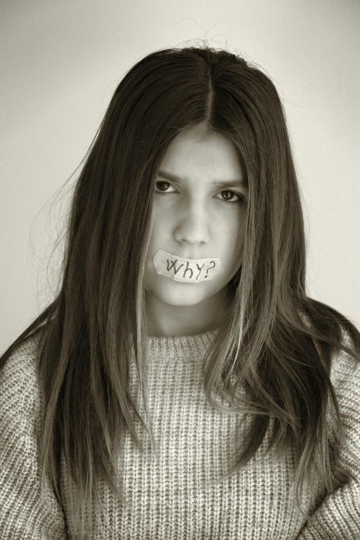 A young woman with tape across her mouth, symbolizing a lack of voice or expression.